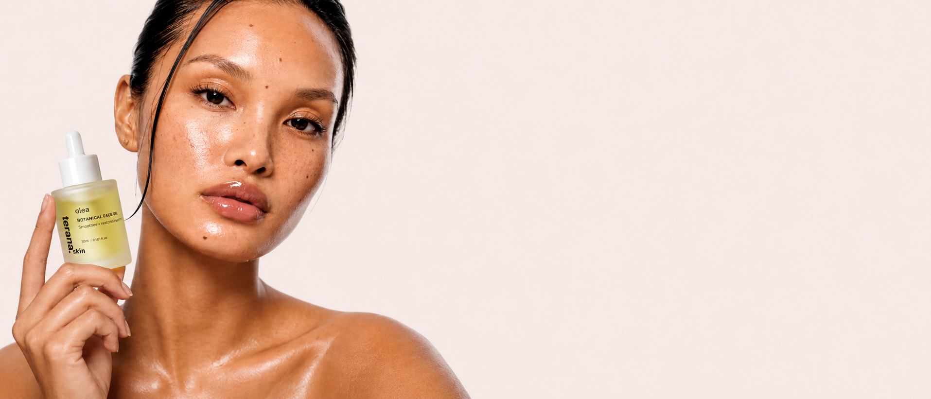 Woman holding a skincare product against a beige background