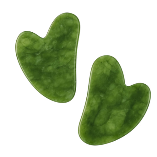 Two green jade gua sha tools on a white background