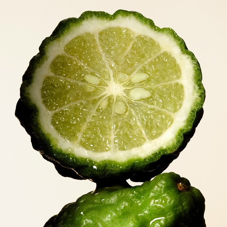 Green fruit cut in half on a beige background